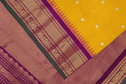 Handwoven Gadwal pure silk saree in mustard with round motifs on the body .
