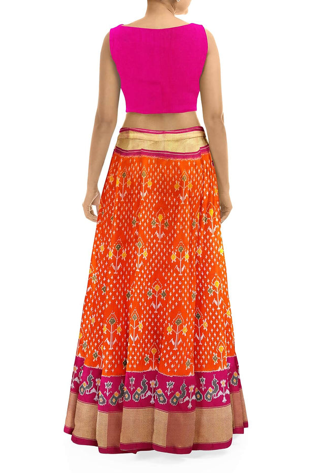 Handwoven Ikat pure silk unstitched lehenga material in orange  with plant motifs.