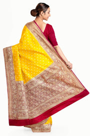 Banarasi silk georgette saree  in yellow with small motifs all over the body.