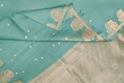 Banarasi kora (organza) silk saree in mint green with small floral motifs in gold & silver .