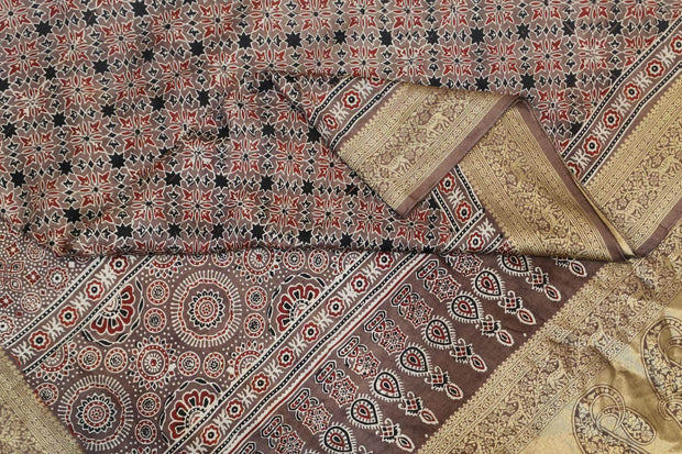 Dola silk saree in chickoo colour  with hand block Ajrakh print  with  paisley motifs in rich tissue pallu
