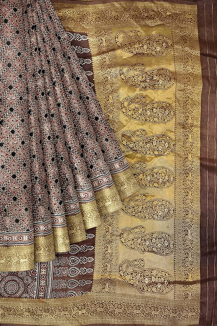Dola silk saree in chickoo colour  with hand block Ajrakh print  with  paisley motifs in rich tissue pallu