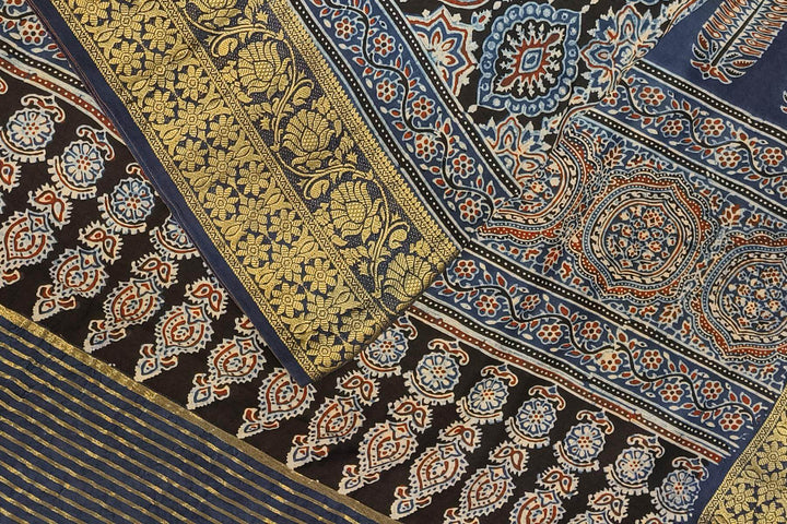 Dola silk saree in blue & black with floral motifs in  hand block Ajrakh print .