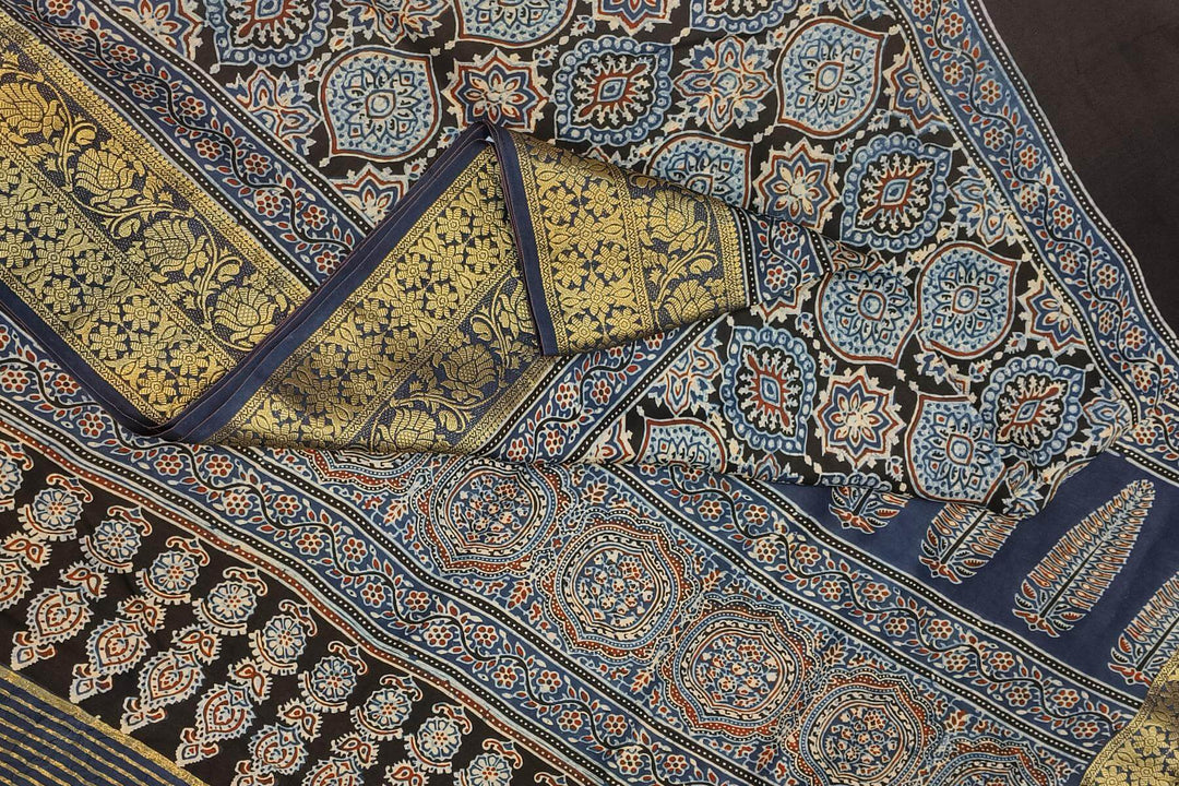 Dola silk saree in blue & black with floral motifs in  hand block Ajrakh print .