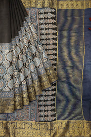 Dola silk saree in blue & black with floral motifs in  hand block Ajrakh print .