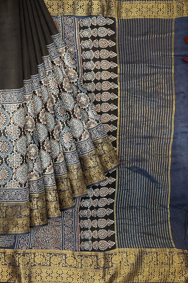 Dola silk saree in blue & black with floral motifs in  hand block Ajrakh print .