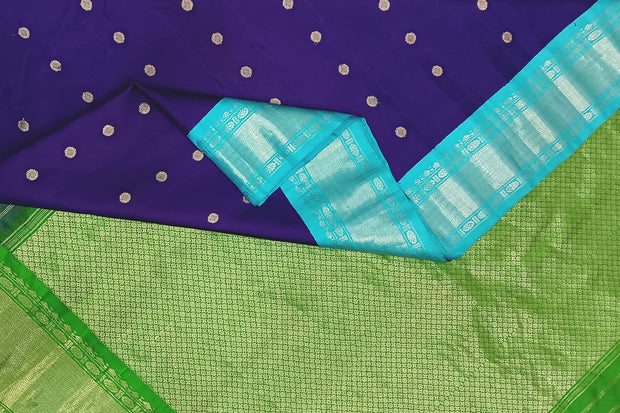Handwoven Gadwal pure silk saree in violet  with round motifs and  a contrast pallu in green .