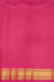Handwoven Gadwal pure silk saree in bottle green  with small motifs   and  a contrast pallu in pink .