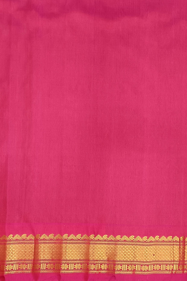 Handwoven Gadwal pure silk saree in bottle green  with small motifs   and  a contrast pallu in pink .