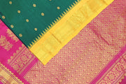 Handwoven Gadwal pure silk saree in bottle green  with small motifs   and  a contrast pallu in pink .