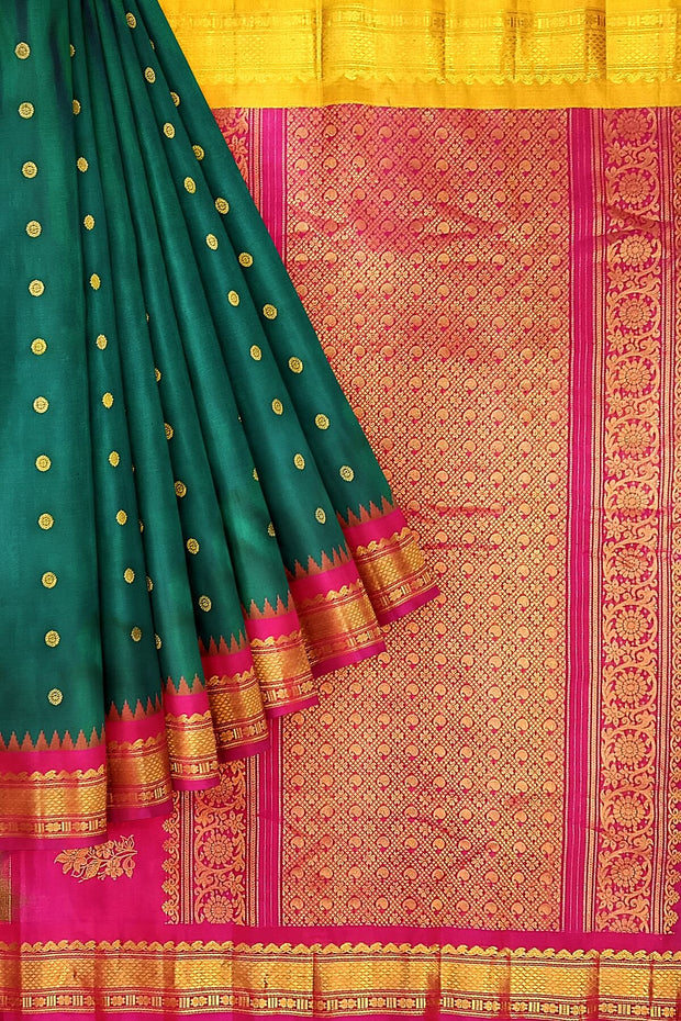 Handwoven Gadwal pure silk saree in bottle green  with small motifs   and  a contrast pallu in pink .