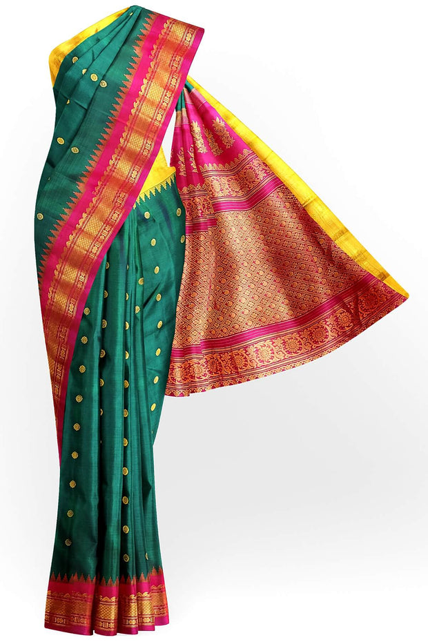 Handwoven Gadwal pure silk saree in bottle green  with small motifs   and  a contrast pallu in pink .