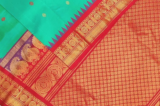 Handwoven Gadwal pure silk saree in  rama  green with  colourful  motifs on the body .