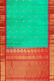 Handwoven Gadwal pure silk saree in  rama  green with  colourful  motifs on the body .
