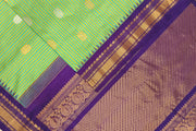 Handwoven Gadwal pure silk saree in fine checks in green & yellow  with gold & silver motifs all over the body.