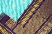 Handwoven Gadwal pure silk saree in fine checks in sky blue  & white  with gold & silver motifs all over the body.
