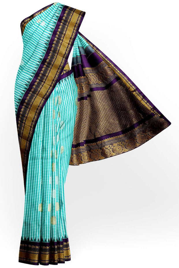 Handwoven Gadwal pure silk saree in fine checks in sky blue  & white  with gold & silver motifs all over the body.