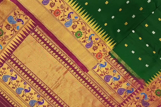 Handwoven Gadwal pure silk saree in bottle green with gold & silver motifs  all over the body.