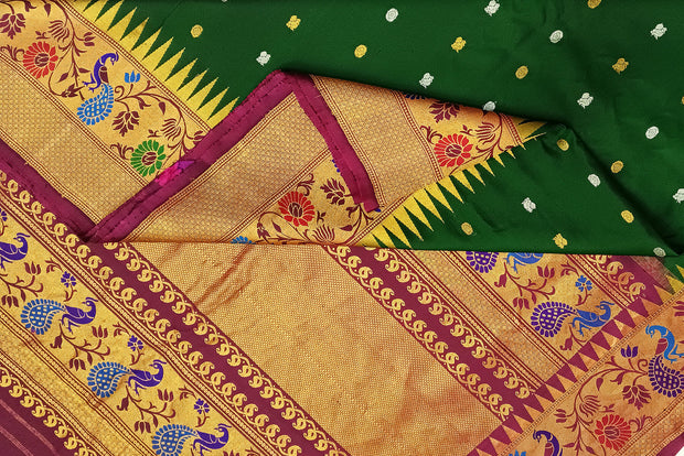 Handwoven Gadwal pure silk saree in bottle green with gold & silver motifs  all over the body.