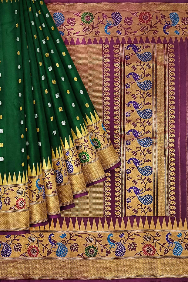 Handwoven Gadwal pure silk saree in bottle green with gold & silver motifs  all over the body.