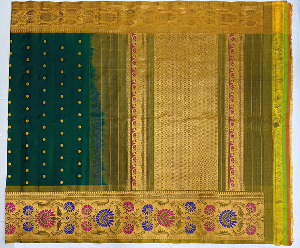 Handwoven Gadwal pure silk saree in bottle green with gold  motifs  all over the body.