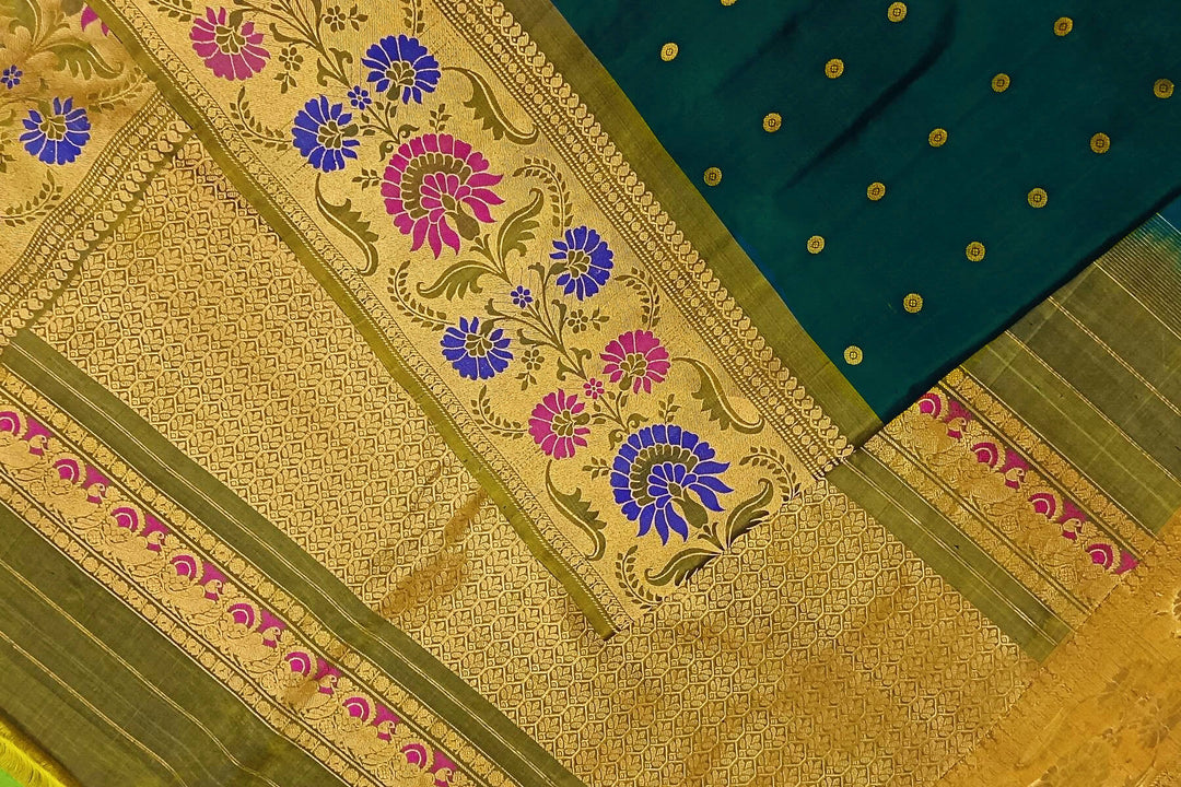 Handwoven Gadwal pure silk saree in bottle green with gold  motifs  all over the body.