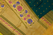 Handwoven Gadwal pure silk saree in bottle green with gold  motifs  all over the body.