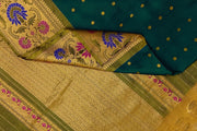 Handwoven Gadwal pure silk saree in bottle green with gold  motifs  all over the body.