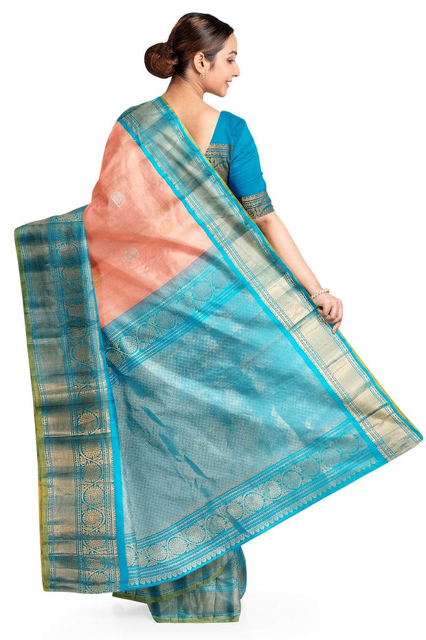 Handwoven Gadwal pure silk saree in peach with floral motifs in gold & silver.