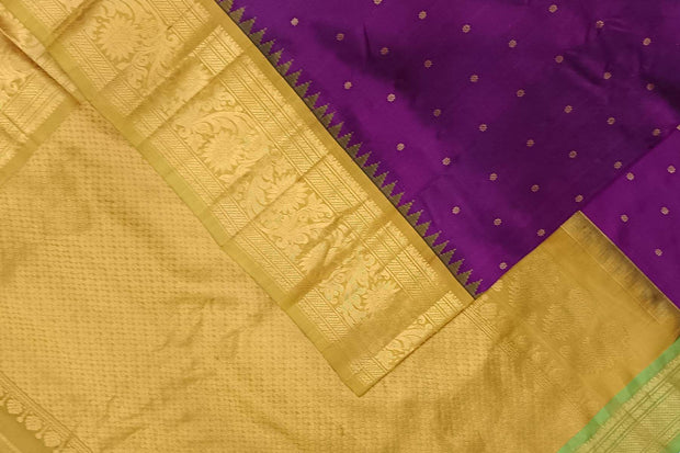 Handwoven Gadwal pure silk saree in purple with floral  motifs in gold .