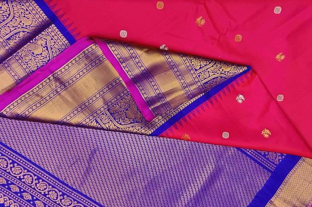 Gadwal pure silk saree in pinkish red with  peacock & disc motif in gold & silver.