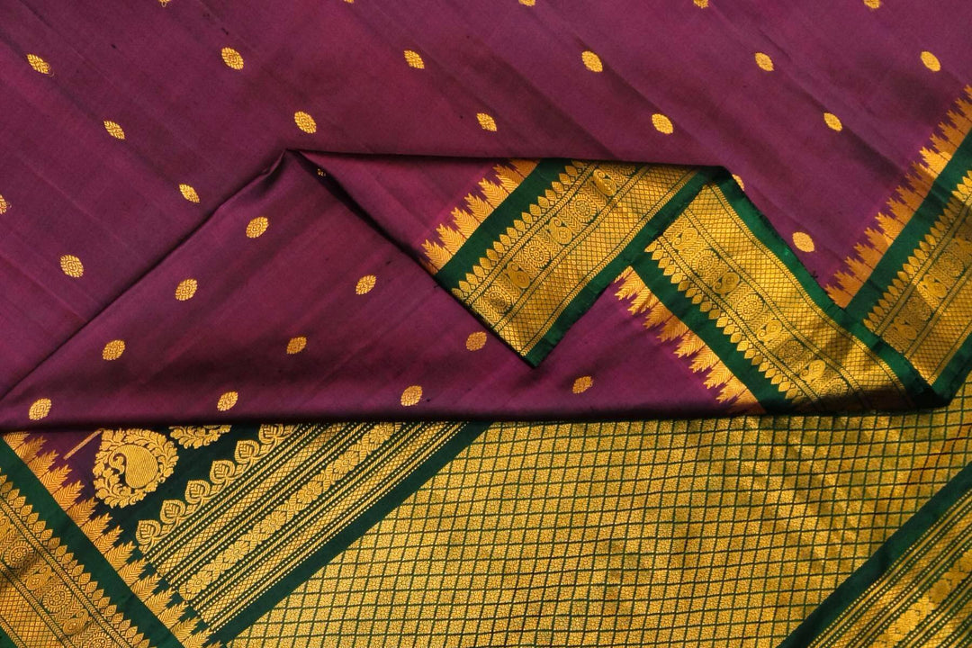 Handwoven Gadwal pure silk saree in  wine with small buttis on the body .