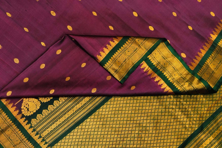 Handwoven Gadwal pure silk saree in  wine with small buttis on the body .