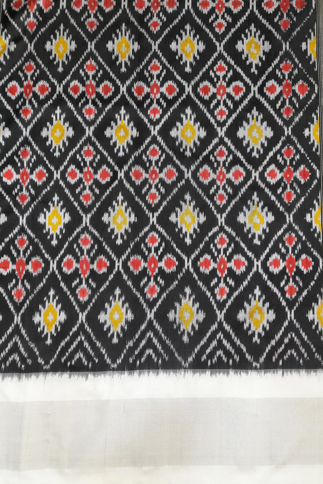 Ikat pure silk saree in black with floral motifs  and silver borders.