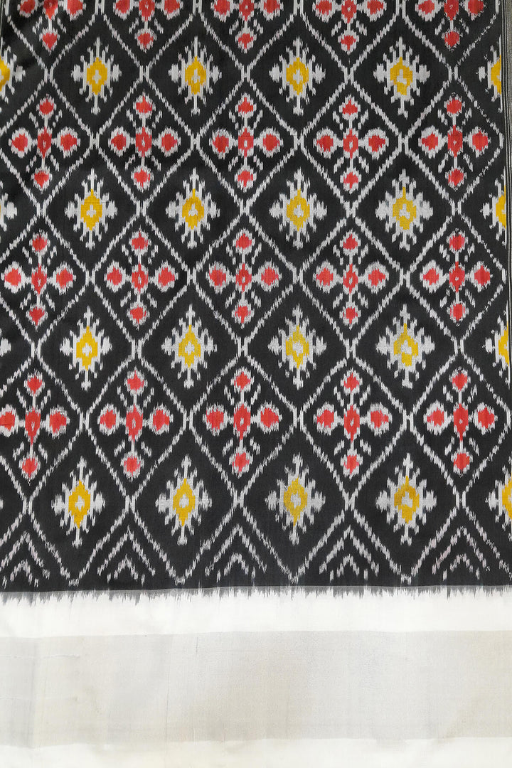 Ikat pure silk saree in black with floral motifs  and silver borders.