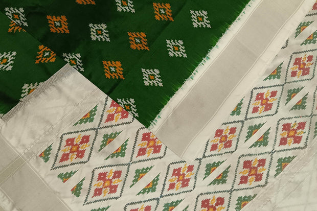 Ikat pure silk sare in dark green in chokta bhat pattern and tissue borders.