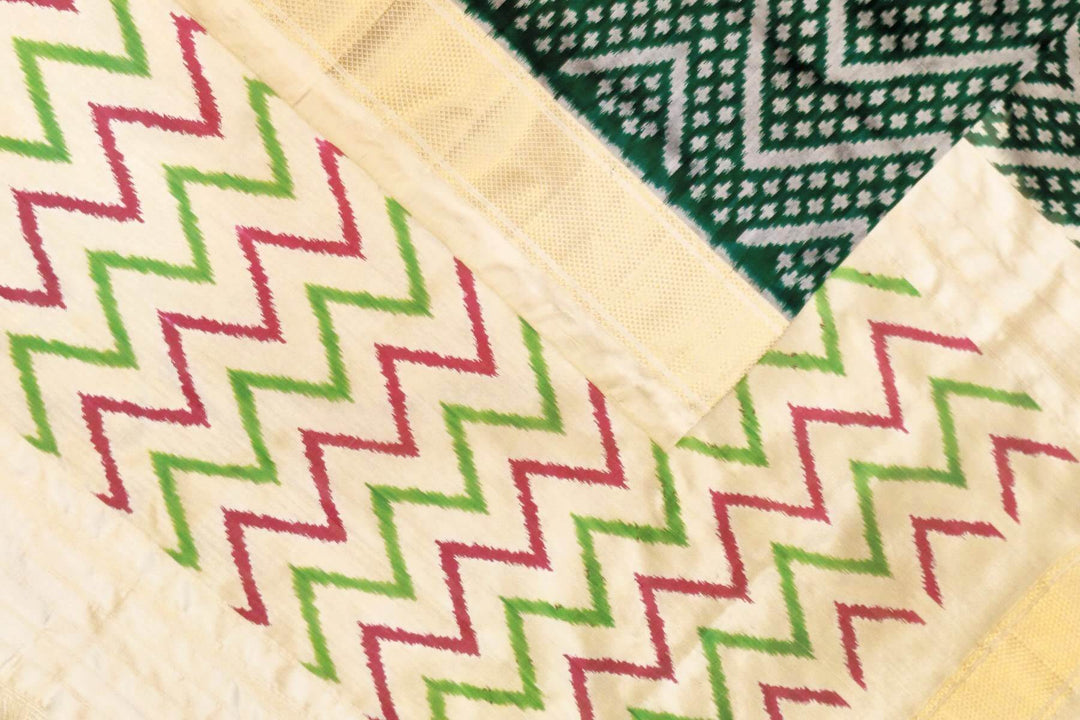 Ikkat pure silk saree in bottle green in zig zag pattern.