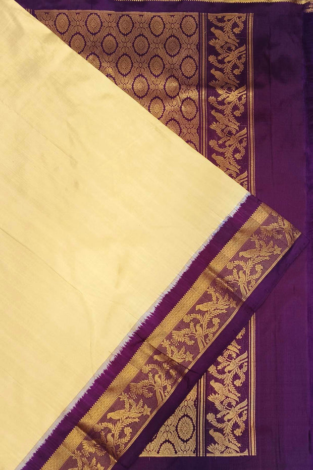 Handwoven Kanchi pure silk saree in off white and a contrast pallu in purple.