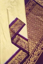 Handwoven Kanchi pure silk saree in off white and a contrast pallu in purple.
