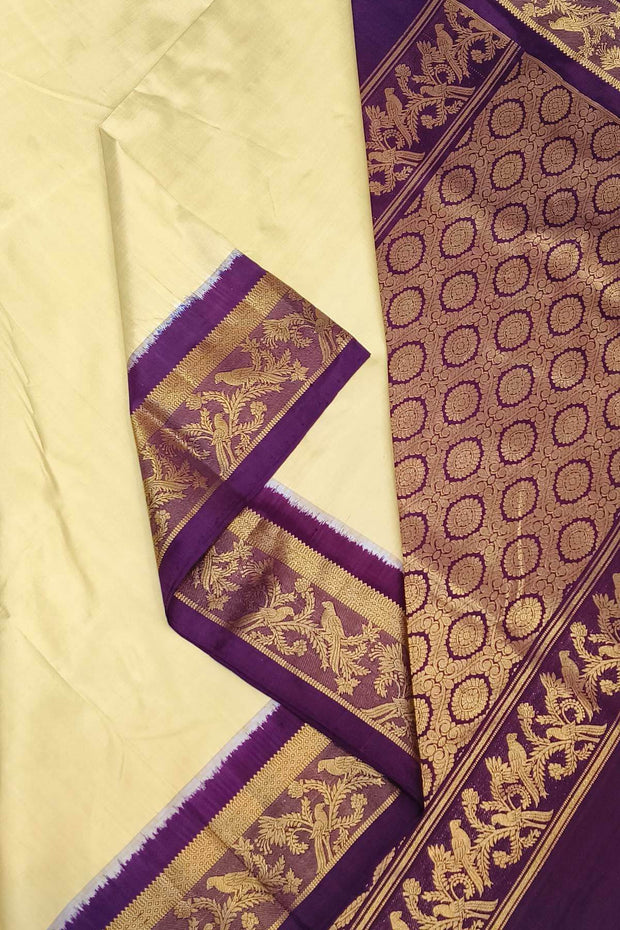 Handwoven Kanchi pure silk saree in off white and a contrast pallu in purple.