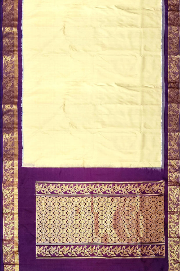 Handwoven Kanchi pure silk saree in off white and a contrast pallu in purple.