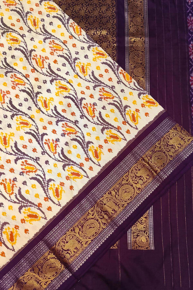 Handwoven Ikkat pure silk saree in off white with floral vines .