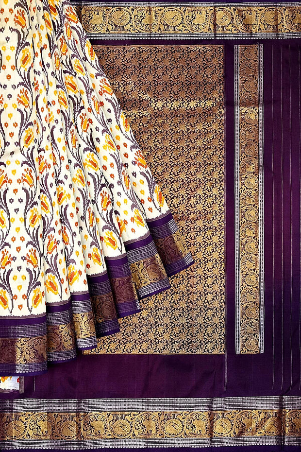 Handwoven Ikkat pure silk saree in off white with floral vines .