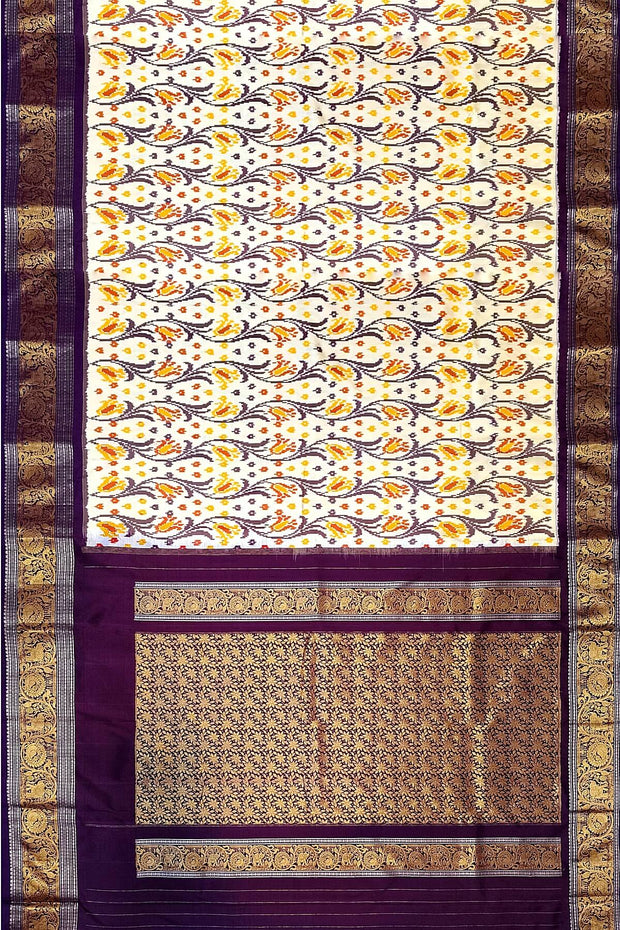 Handwoven Ikkat pure silk saree in off white with floral vines .