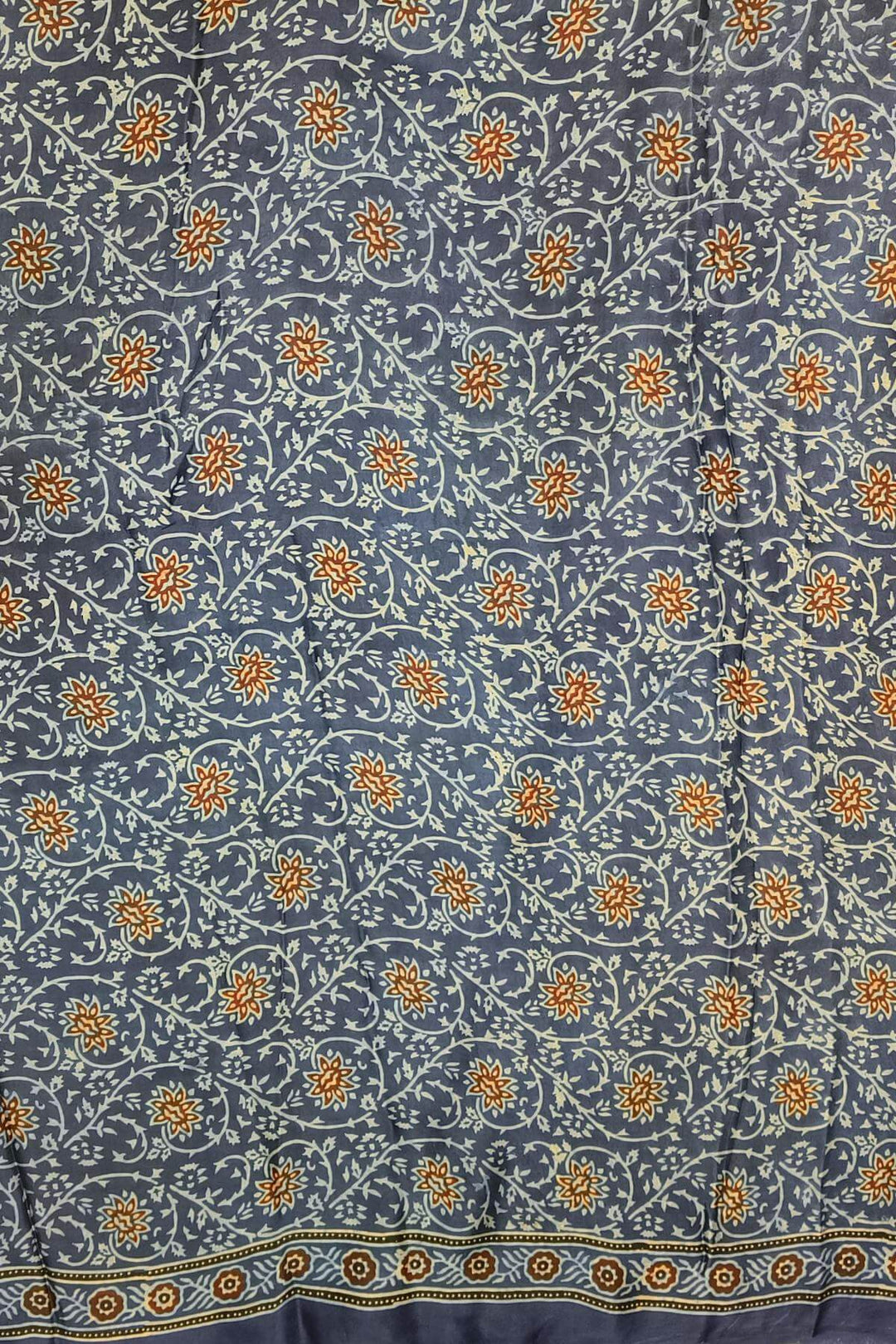 Dola silk saree in blue  with floral motifs in  hand block Ajrakh print .