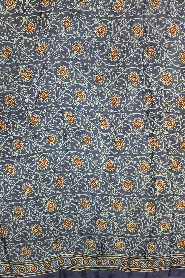Dola silk saree in blue  with floral motifs in  hand block Ajrakh print .