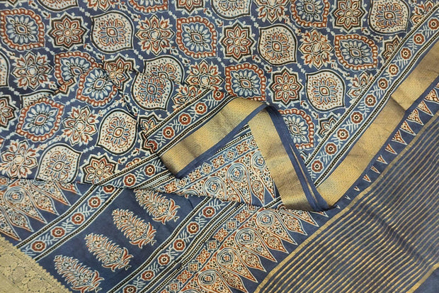 Dola silk saree in blue  with floral motifs in  hand block Ajrakh print .