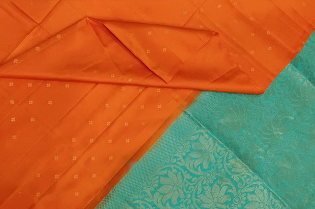 Kanchi soft silk saree in orange with small motifs on the body and floral vines in pallu