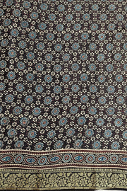 Modal silk saree in black  in hand block ajrakh print with zari border.