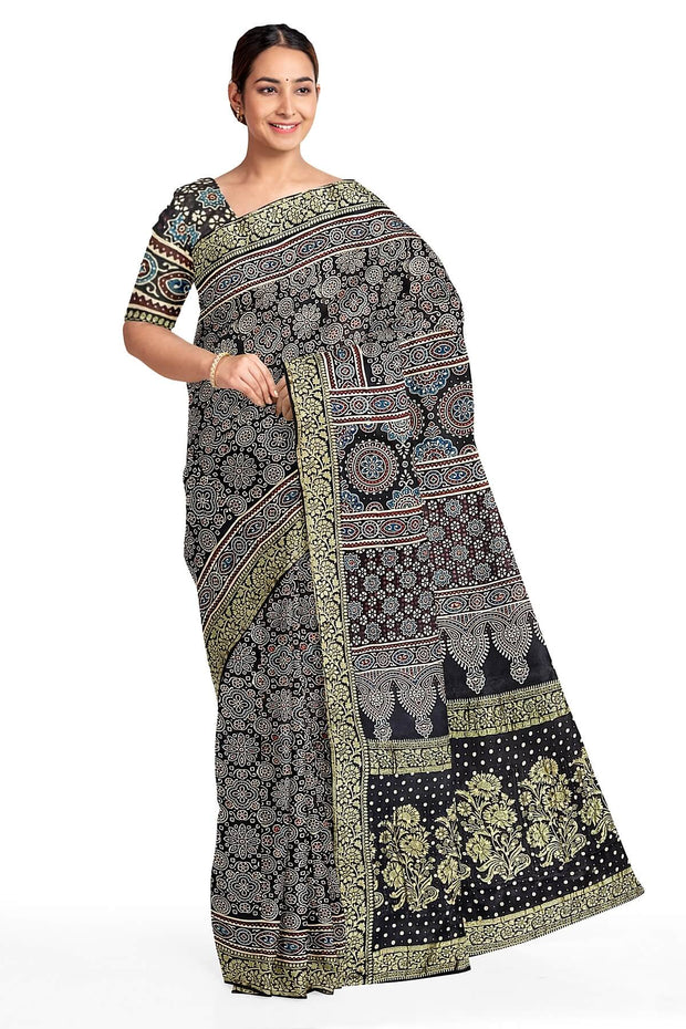 Modal silk saree in black in hand block ajrakh print with zari border.